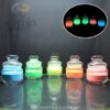 Coloured glow powders in glass jars with an inset showing their glow