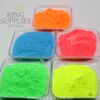 Orange, blue, pink, green and yellow glow powders in trays