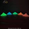 Five coloured glow powders photographed in the dark