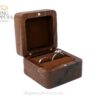 Open walnut ring box with a brown cushion holding one ring