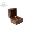 Open walnut ring box with a brown cushion holding two rings