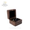 Open walnut ring box with a black cushion holding one ring
