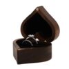 Heart-shaped wooden ring box with black cushions holding two rings