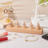 Wooden ring display stand with five cones on a dressing table
