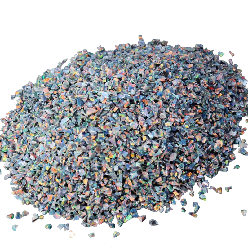 Iridescent crushed opal chips with blue, green, orange and pink flashes, isolated on a transparent background.